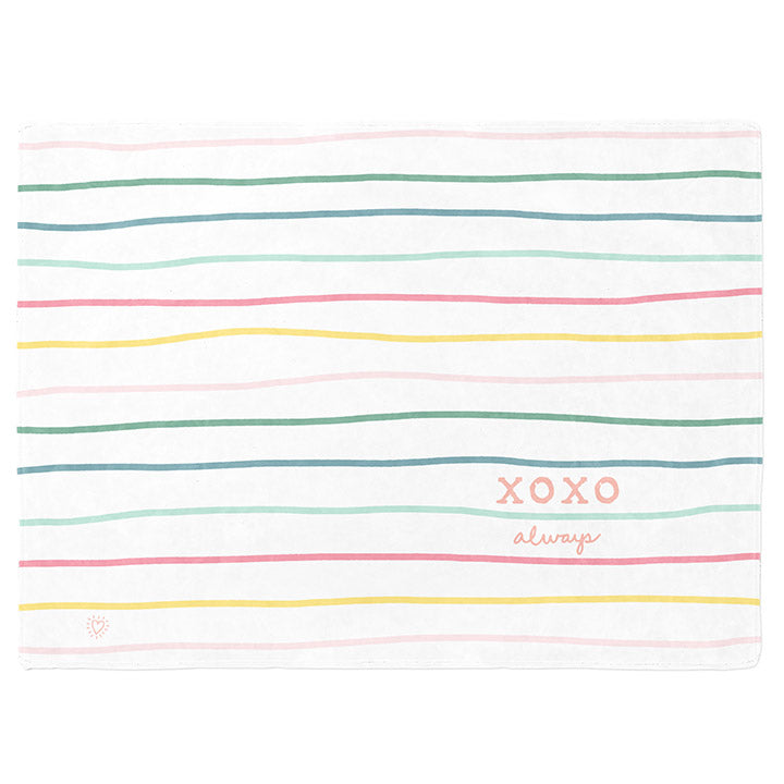 50 by 60 inch silky-soft fleece blanket that is hypoallergenic. Perfect size for an adult. Bright white blanket printed on one side only. 13 colorful hand drawn stripes of pink, green, blue, light teal, magenta and bright yellow run horizontally with the words xoxo, always in typewriter font. Adoptionly Yours heart logo by itself in pink in lower left corner of blanket on front. 