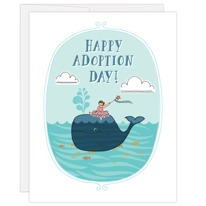 4.25 x 5.5 inch greeting card. Blank inside. Colorful line illustration of a wand-waving little girl sitting atop a smiling whale in an ocean of swimming fish. Colors are blues and pinks, with orange and yellow fish. Illustrated text reads: Happy Adoption Day!
