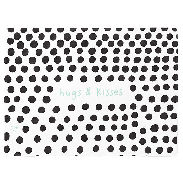 30 by 40 inch silky-soft fleece blanket that is hypoallergenic. Perfect size for a toddler or child. Bright white blanket printed on one side only. 3 inch hand drawn black dots scattered across blanket with the words hugs & kisses hand drawn in a mint green color. A small Adoptionly Yours heart logo by itself in mint green in lower left corner of blanket on front. 