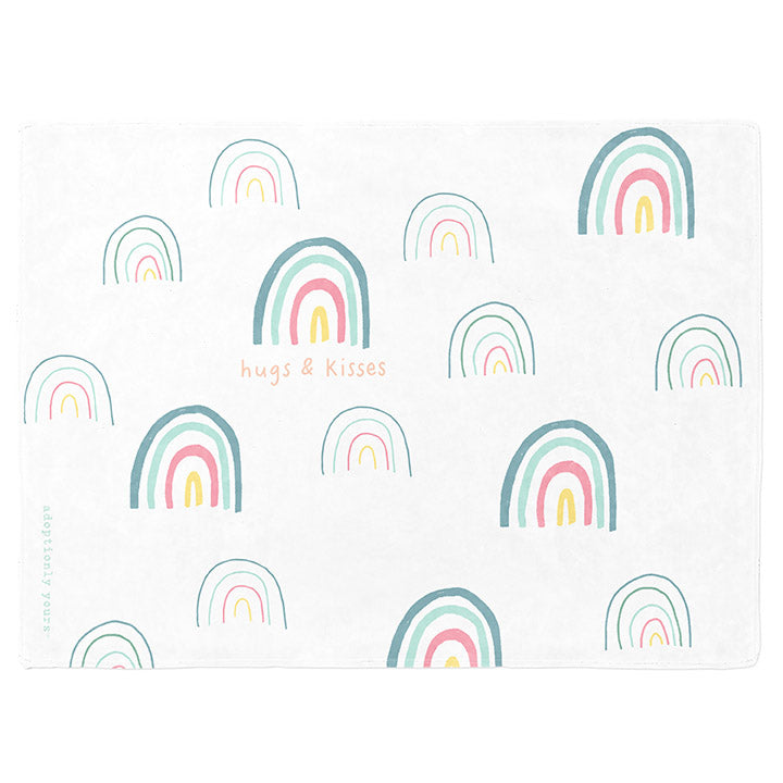 30 by 40 inch silky-soft fleece blanket that is hypoallergenic. Perfect size for a toddler or child. Bright white blanket printed on one side only. 15 large and small hand drawn rainbows scattered across blanket in magenta, light teal, bright yellow and green with the words hugs & kisses hand drawn in peach color. The words adoptionly yours in light teal typewriter font on lower left corner of blanket on front. 