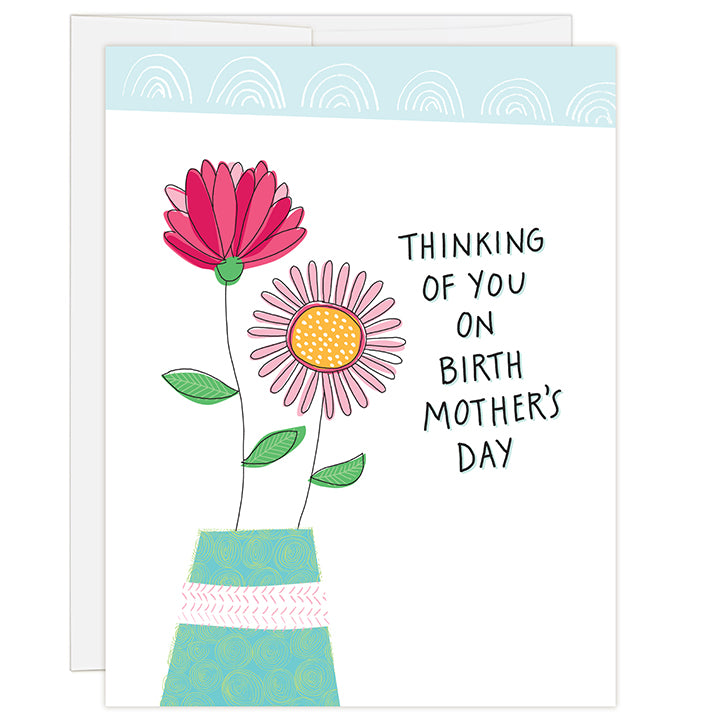 4.25 x 5.5 inch greeting card. Blank inside. Simple and charming illustration style. Title Thinking of you on birth mother’s day. Drawing of a teal colored vase with two large flowers, one large pink and magenta and the other pink with a yellow center.