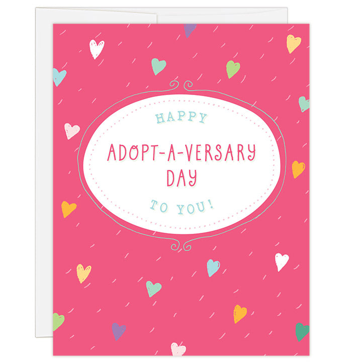 4.25 x 5.5 inch greeting card. Blank inside. Simple and charming illustration style. Title Happy Adopt-A-versary Day to You! Title is in white oval. Background color is magenta with brightly colored hearts. Title is in white oval. 