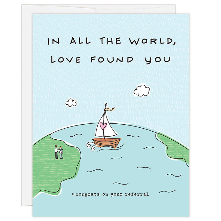 4.25 x 5.5 inch greeting card. Blank inside. Simple and charming illustration style. Title In All The World, Love Found You. Subtitle *congrats on your referral. Drawing of the earth with a sailboat crossing the sea to a couple on land. Sailboat has a pink heart on the mast of the sailboat.