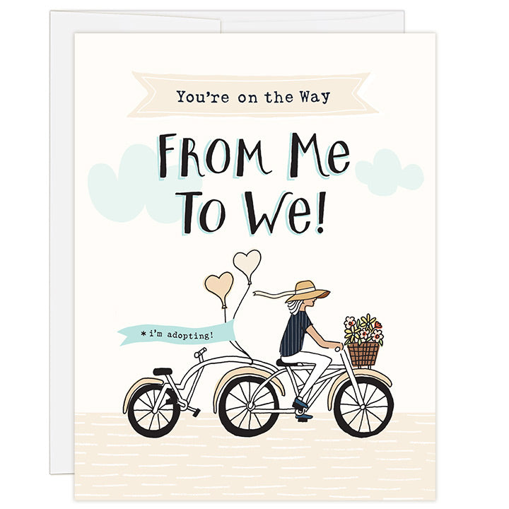 4.25 x 5.5 inch greeting card. Blank inside. Simple and charming illustration style. Title You’re on the Way From Me to We! Sub title *i’m adopting! Main image is a woman on a tandem bicycle and back seat is empty. There are flowers in the basket and balloons on the back with the words i’m adopting! Adoption greeting card for supporting a single woman on the adoption journey.