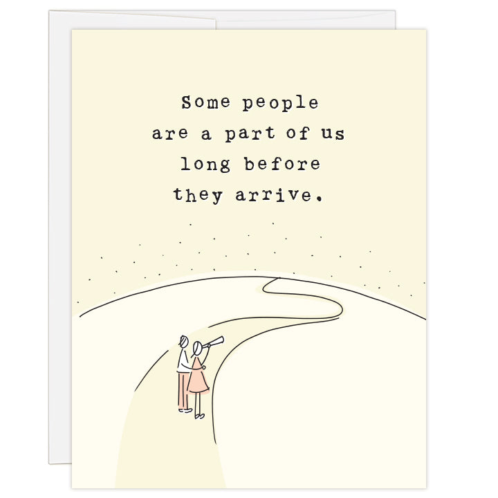 4.25 x 5.5 inch adoption greeting card for hopeful parents waiting for a child to come. Blank inside. Charmingly simple line illustration of a couple standing at the foot of a winding road looking through a telescope toward the end of the earth. Pale yellow and soft pink colors. Typewriter text reads: Some people are a part of us long before they arrive.
