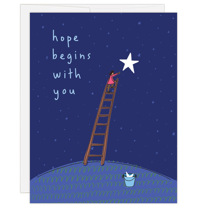 4.25 x 5.5 inch greeting card. Blank inside. Simple line illustration features woman atop a ladder reaching toward a large star in a star-filled night sky. At the foot of the ladder rests a bucket holding a star. Shades of blue. Text reads: hope begins with you. Adoption encouragement card.