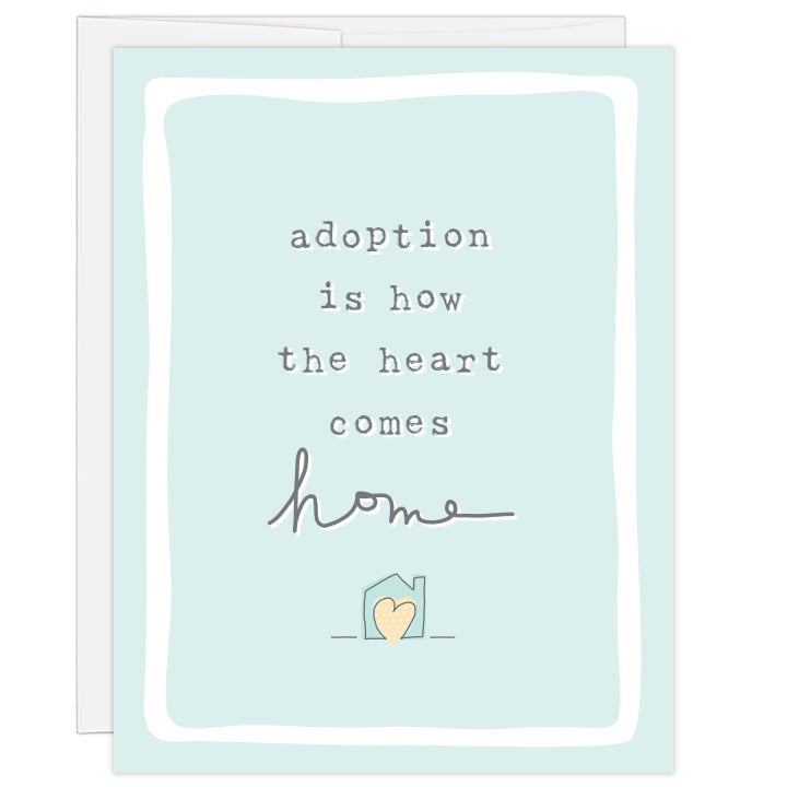 4.25 x 5.5 inch greeting card. Blank inside. Front of card features light blue background with simple line drawing of a small house with a yellow heart inside. Text reads: adoption is how the heart comes home. 