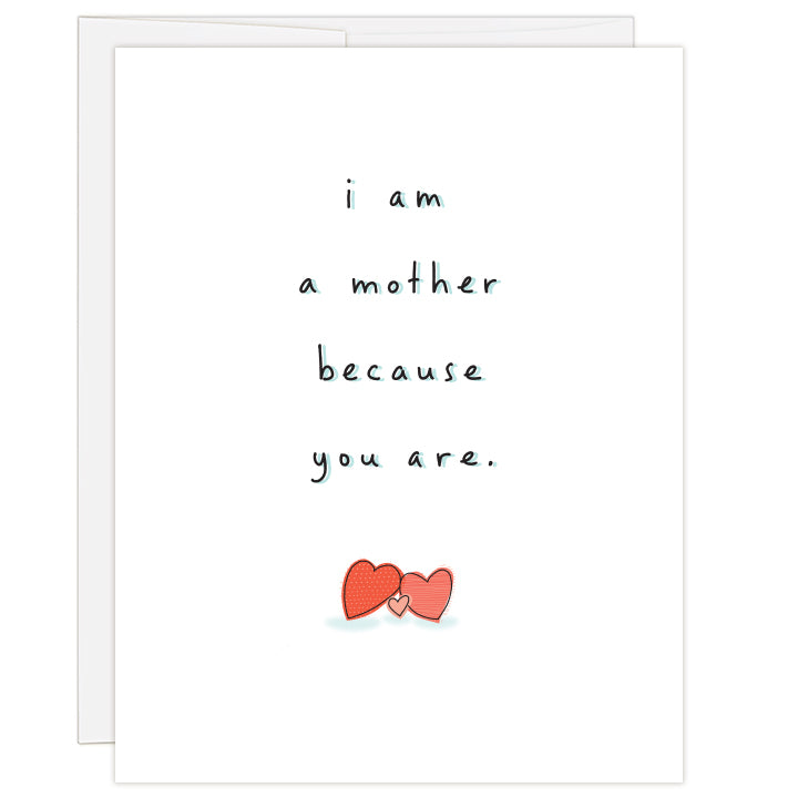 4.25 x 5.5 inch greeting card. Blank inside.  White card with three red and pink hearts leaning against one another beneath the message: i am a mother because you are.