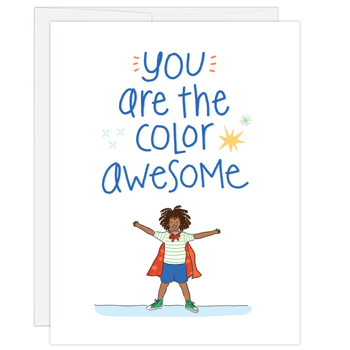 4.25 x 5.5 inch greeting card. Blank inside. White cover with brightly illustrated headline above a young African American boy wearing a striped green and white shirt, blue shorts, green tennis shoes and a red starry cape. Text reads: you are the color awesome.