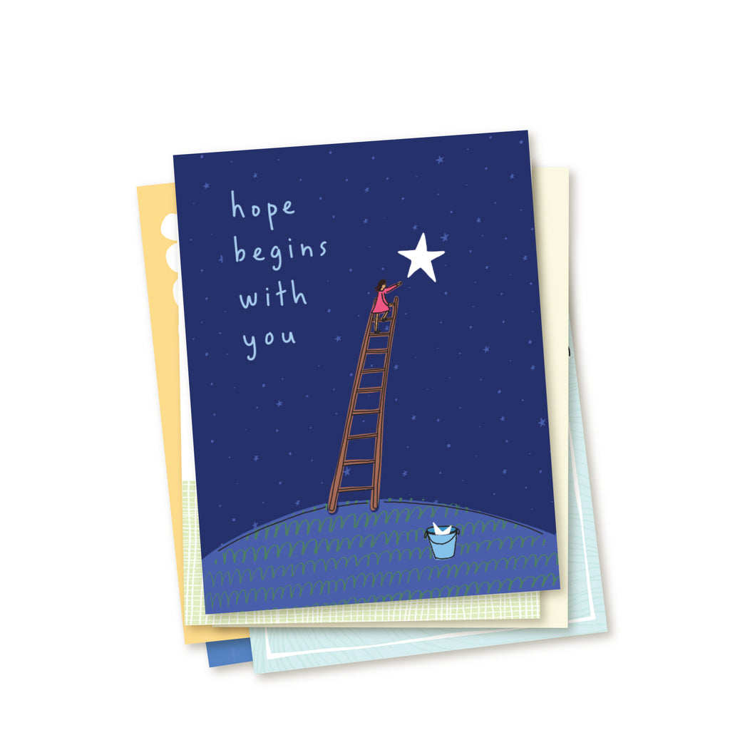 Stacked set of the cards in a six-card set of adoption encouragement greeting cards. Top card shows simple line drawing of a woman climbing a ladder to put a bright star up into a deep blue, star-filled sky. At the foot of the ladder waits a bucket holding another star. Card reads Hope Begins With You in hand-written text. Other cards in the set peek out beneath main card.